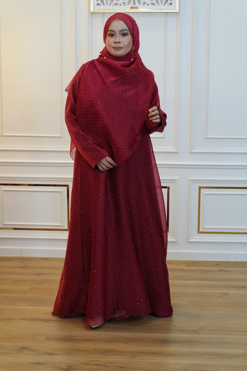 Woman wearing a red abaya with a matching hijab.